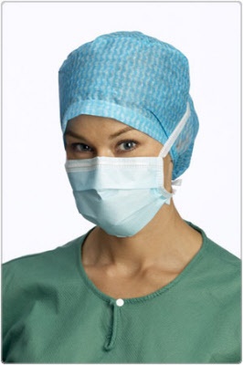 Pessoa com touca médica azul e máscara cirúrgica