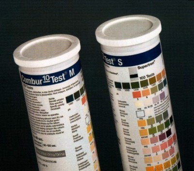 Dois frascos cilindricos brancos para testes com tabelas coloridas em rótulos