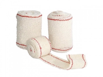 Três rolos de atadura branca com linhas vermelhas