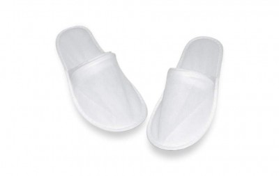 Par de chinelos descartáveis brancos sobre fundo branco