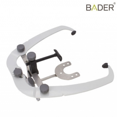 Instrumento odontológico branco e preto com parafusos cinza e marca BADER