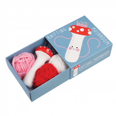 Conjunto de tricô em forma de cogumelo com novelos de lã numa caixa azul