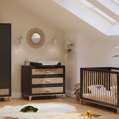 Quarto de bebé com móveis pretos e detalhes em palhinha e luz natural