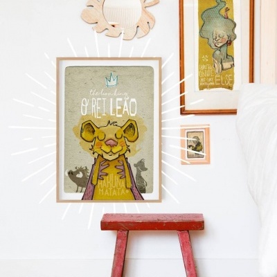 Parede branca com quadros ilustrativos de leão, figura abstrata, banco vermelho e espelho decorativo