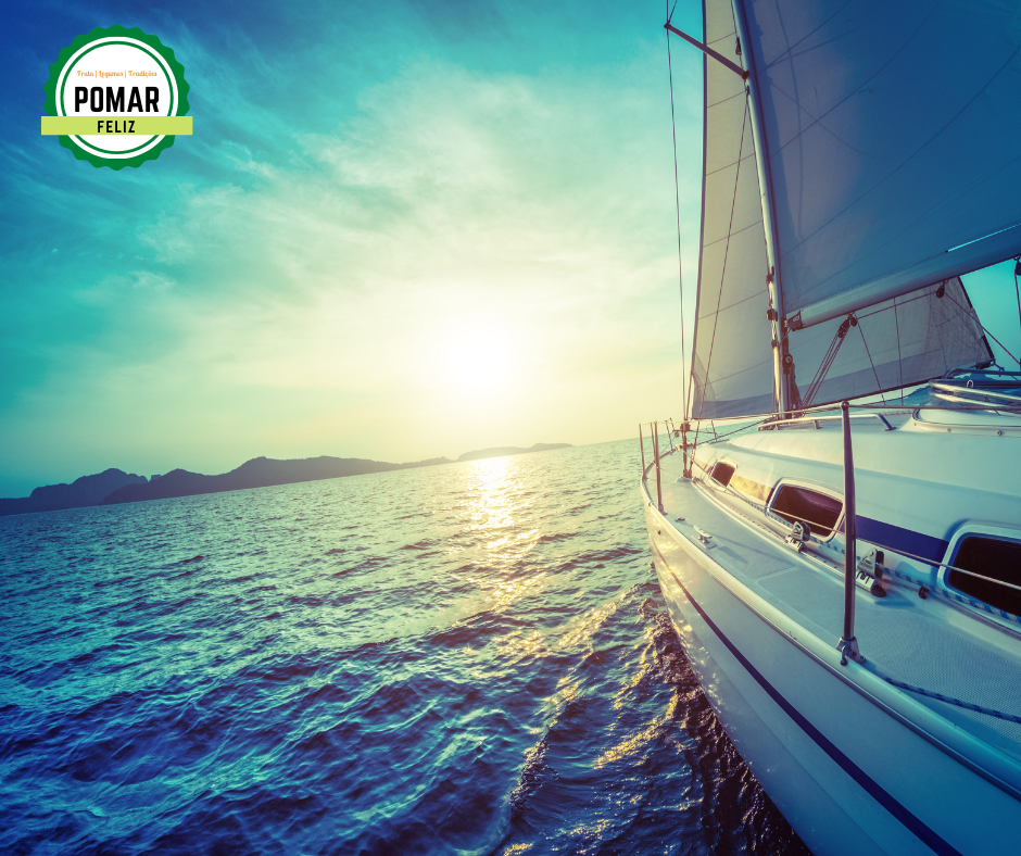 Veleiro branco a navegar ao pôr do sol com selo POMAR FELIZ
