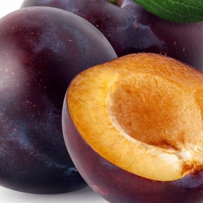 Ameixas inteiras e cortada ao meio com folha verde