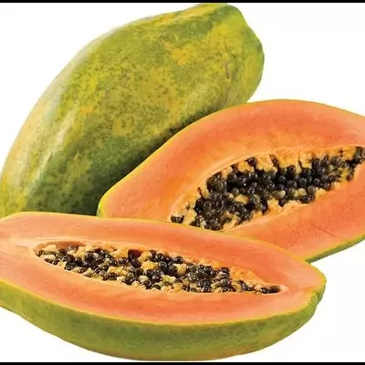 Papaia inteira e cortada ao meio com polpa laranja e sementes pretas visíveis