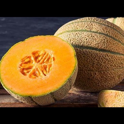Melão cantalupo inteiro e cortado ao meio com polpa laranja brilhante e casca verde texturada