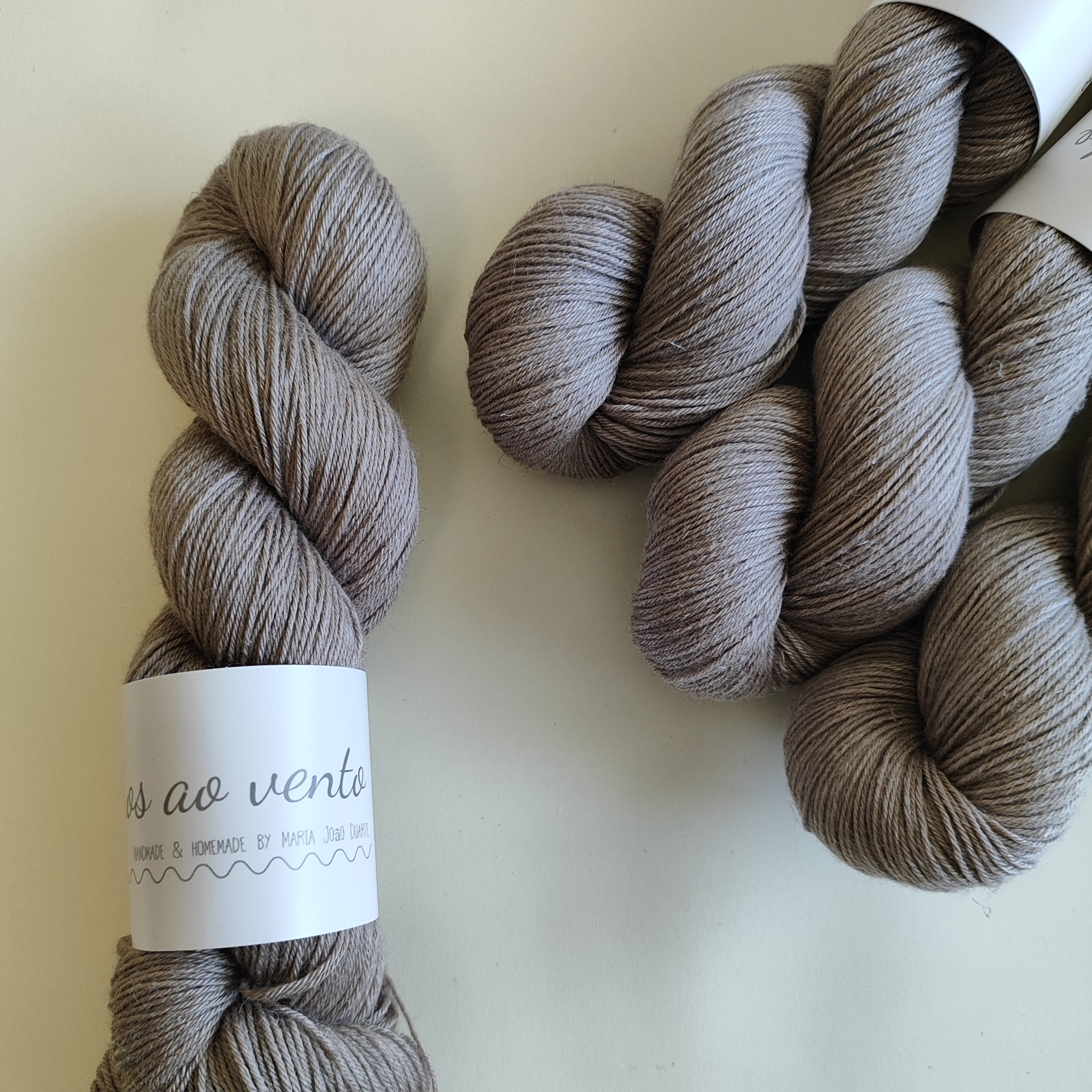 LINEN SILK novelos de lã cinza castanho com embalagem branca e etiqueta com texto manuscrito