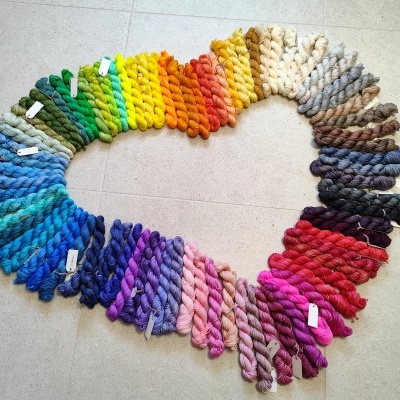 Novelos de fio de lã coloridos dispostos em forma de coração no chão