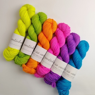 Seis novelos de lã coloridos com rótulos em fundo branco