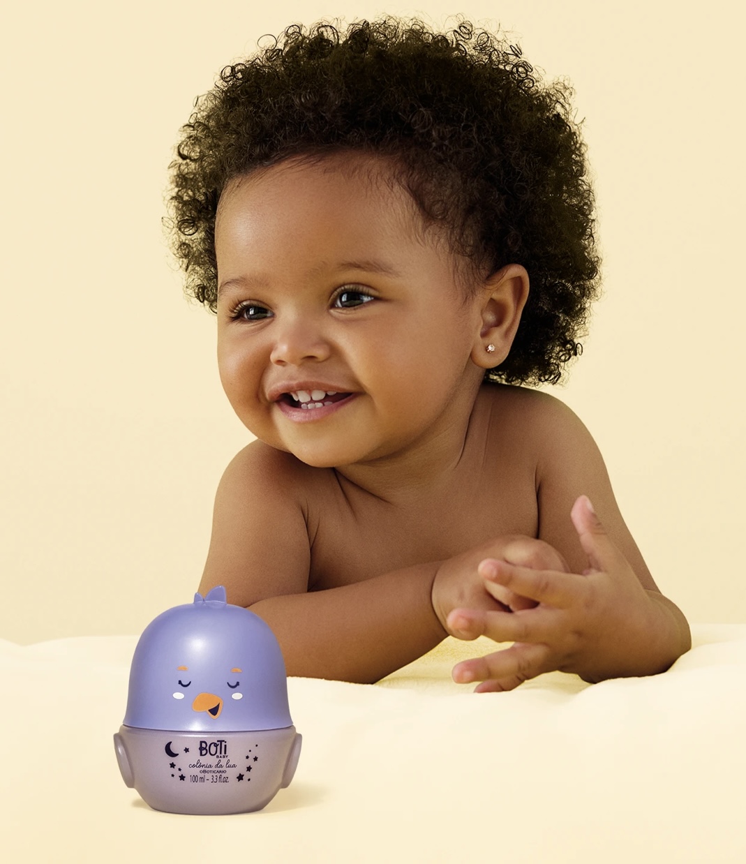 Colónia Lua Boti Baby Criança sorridente com frasco lilás de perfume BOTI BABY colónia da lua