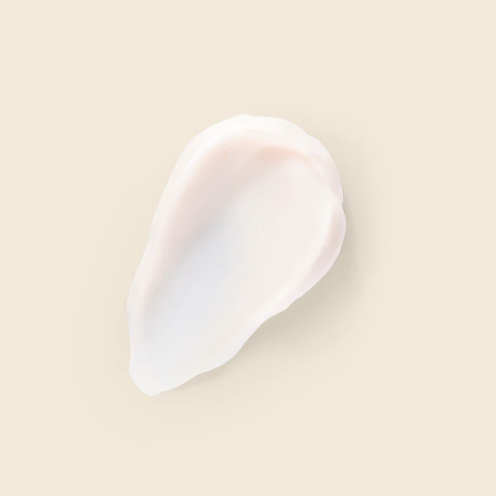 Creme Hidratante Perfumado Nativa SPA Orquídea Lumière, 400ml Amostra de creme branco com textura suave sobre fundo bege