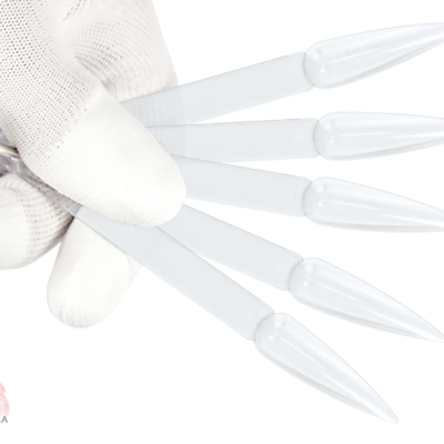 Mão com luva branca segurando placas para amostras de unhas artificiais transparentes