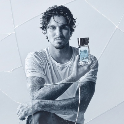 Homem com t-shirt branca molhada segurando perfume CHANEL