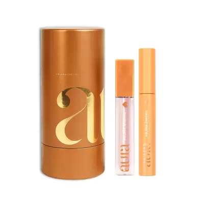 Conjunto de maquilhagem com embalagem castanha e letras douradas e dois produtos Aura Helena Coelho
