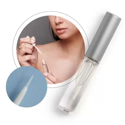 Frasco transparente com tampa prateada e aplicador tipo pincel para produto de beleza líquido