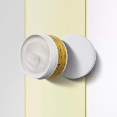 Frasco aberto de creme para cabelo com rótulo amarelo