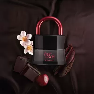 Frasco de perfume her code com flor, chocolate, cereja e madeira sobre tecido escuro