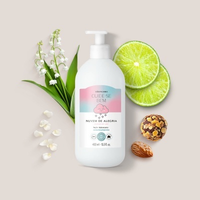 Frasco branco de loção hidratante com doseador e flores brancas, fatias de lima, chocolate e amêndoa ao redor