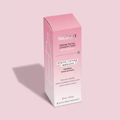 Embalagem rosa e branca de sérum facial skin.q sobre fundo rosa