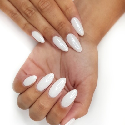 Mãos femininas com unhas brancas e formato amêndoa