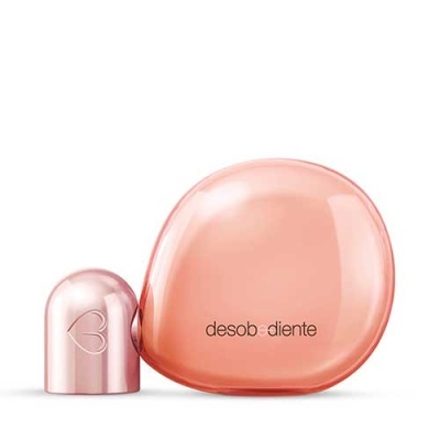 Frasco de perfume rosa com tampa metálica e texto desobediente