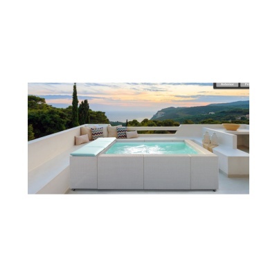 Conjunto de mobiliário de exterior com piscina de hidromassagem e almofadas decorativas num terraço com vista para montanhas ao pôr do sol