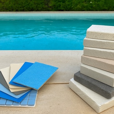 Amostras de azulejos e pedras decorativas azuis e brancas junto a piscina