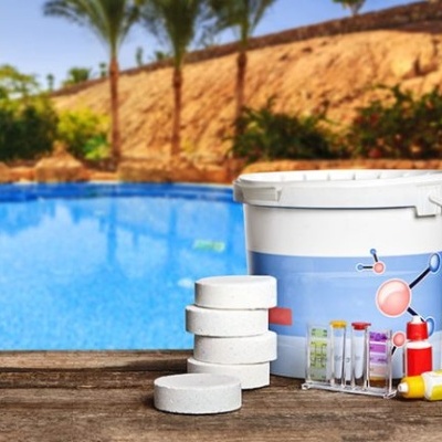 Kit de manutenção para piscina com comprimidos, tubos de teste e balde junto a piscina