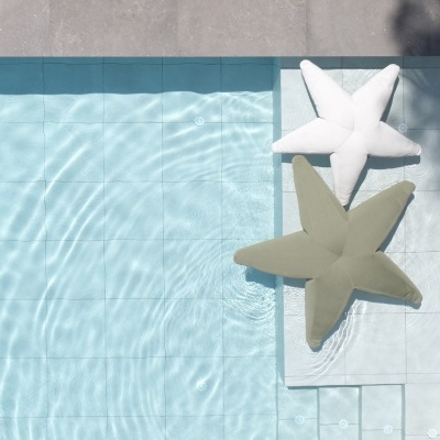 Piscina com almofadas em forma de estrela do mar brancas e verdes na borda