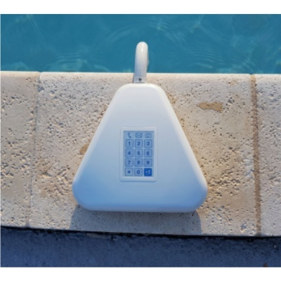 Dispositivo branco com teclado numérico montado em superfície de pedra ao lado de piscina azul