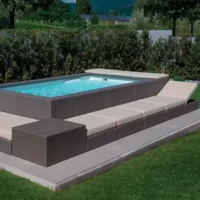 Piscina elevada com estrutura em vime sintético castanho escuro e almofadas bege no exterior