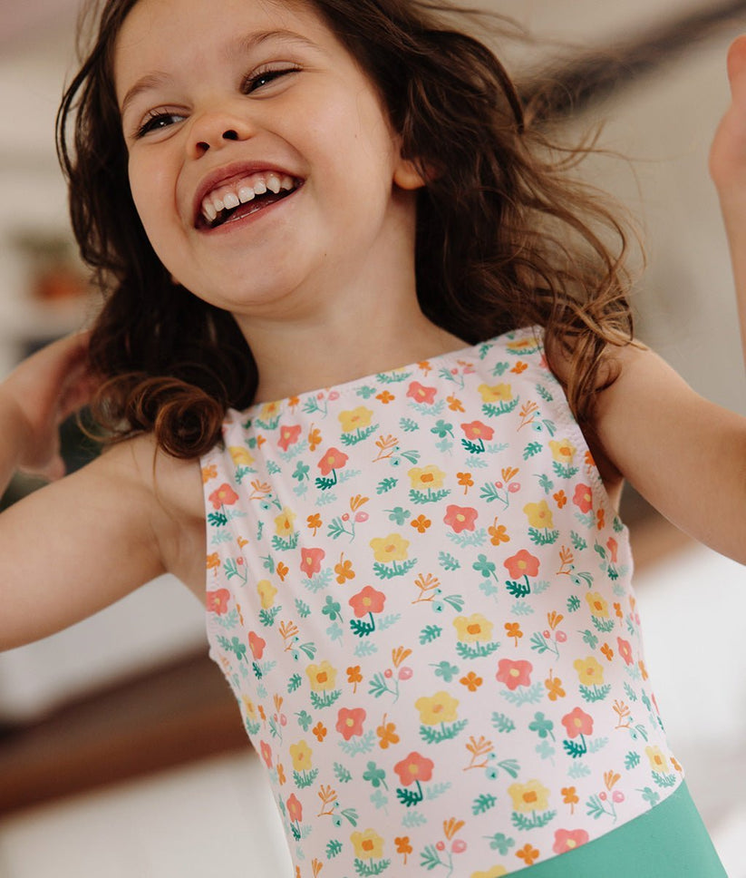 Camisola de criança com padrão floral colorido em fundo branco