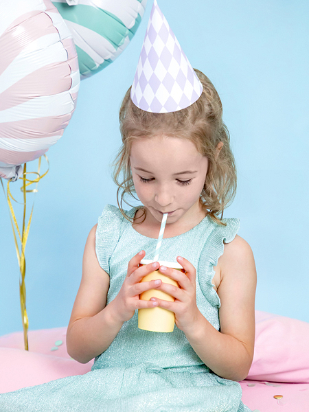 Menina com vestido azul claro e chapéu de festa lilás segurando copo amarelo com palhinha