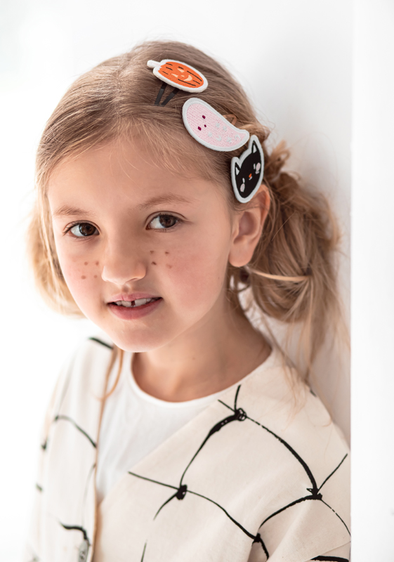 Presilhas de cabelo infantis com abóbora, fantasma e gato em feltro colorido usadas numa menina