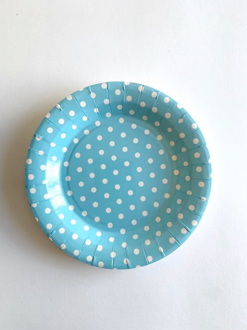Prato descartável azul com bolinhas brancas sobre fundo branco