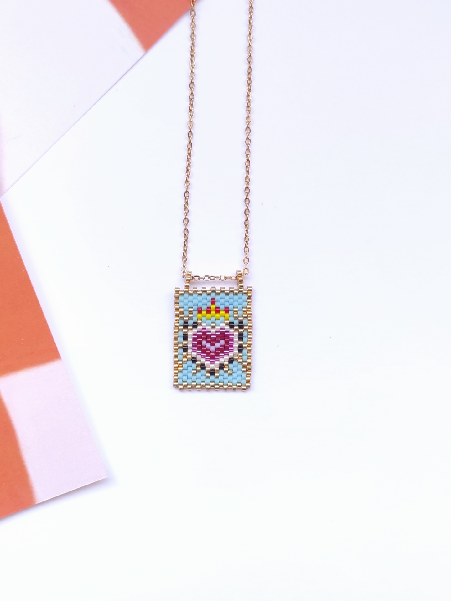 Colar com pendente retangular colorido com padrão de coração e coro a