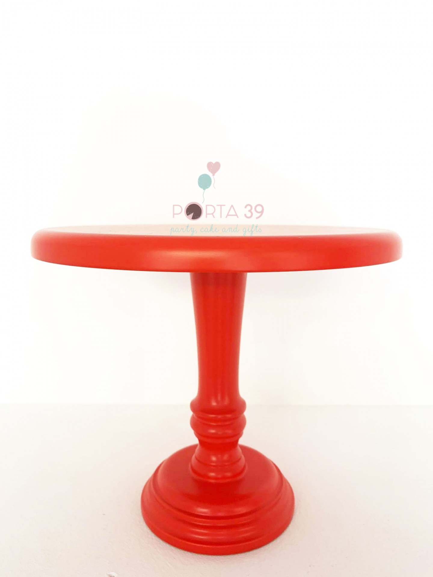 Suporte para bolos vermelho em madeira com base circular e coluna central trabalhada.