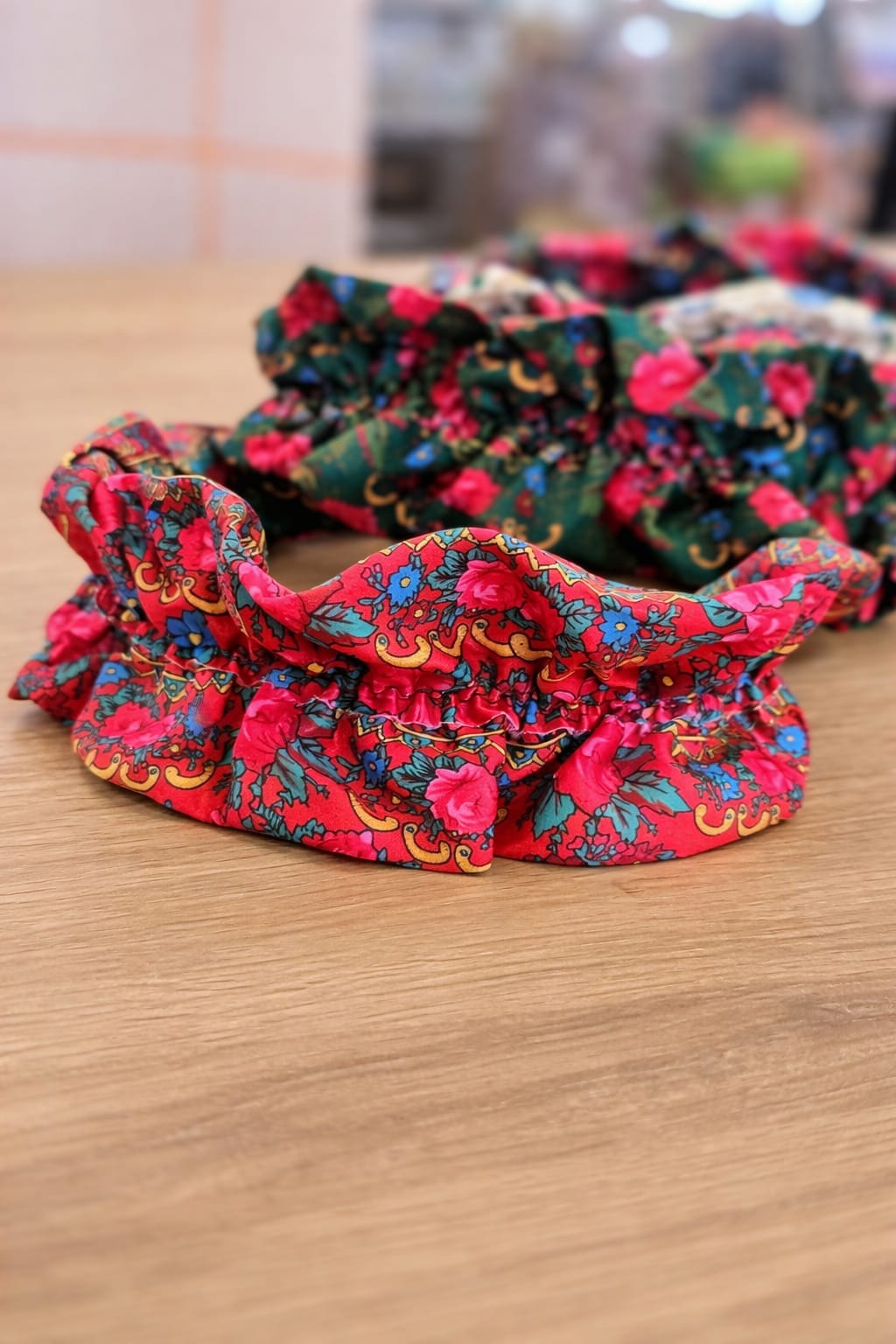 Elásticos para cabelo coloridos com padrão floral sobre mesa de madeira