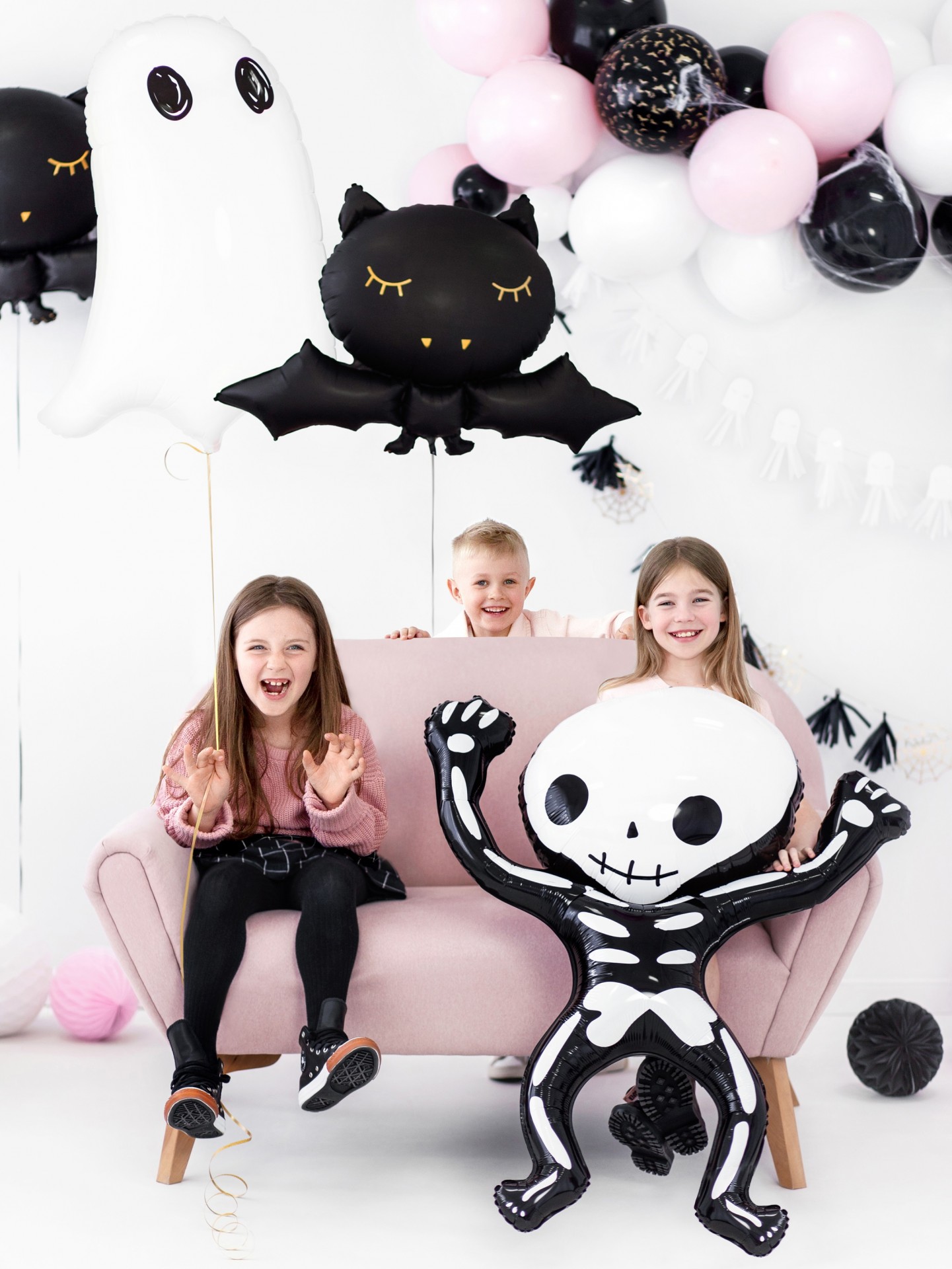 Crianças com balões de Halloween e decoração colorida em fundo branco