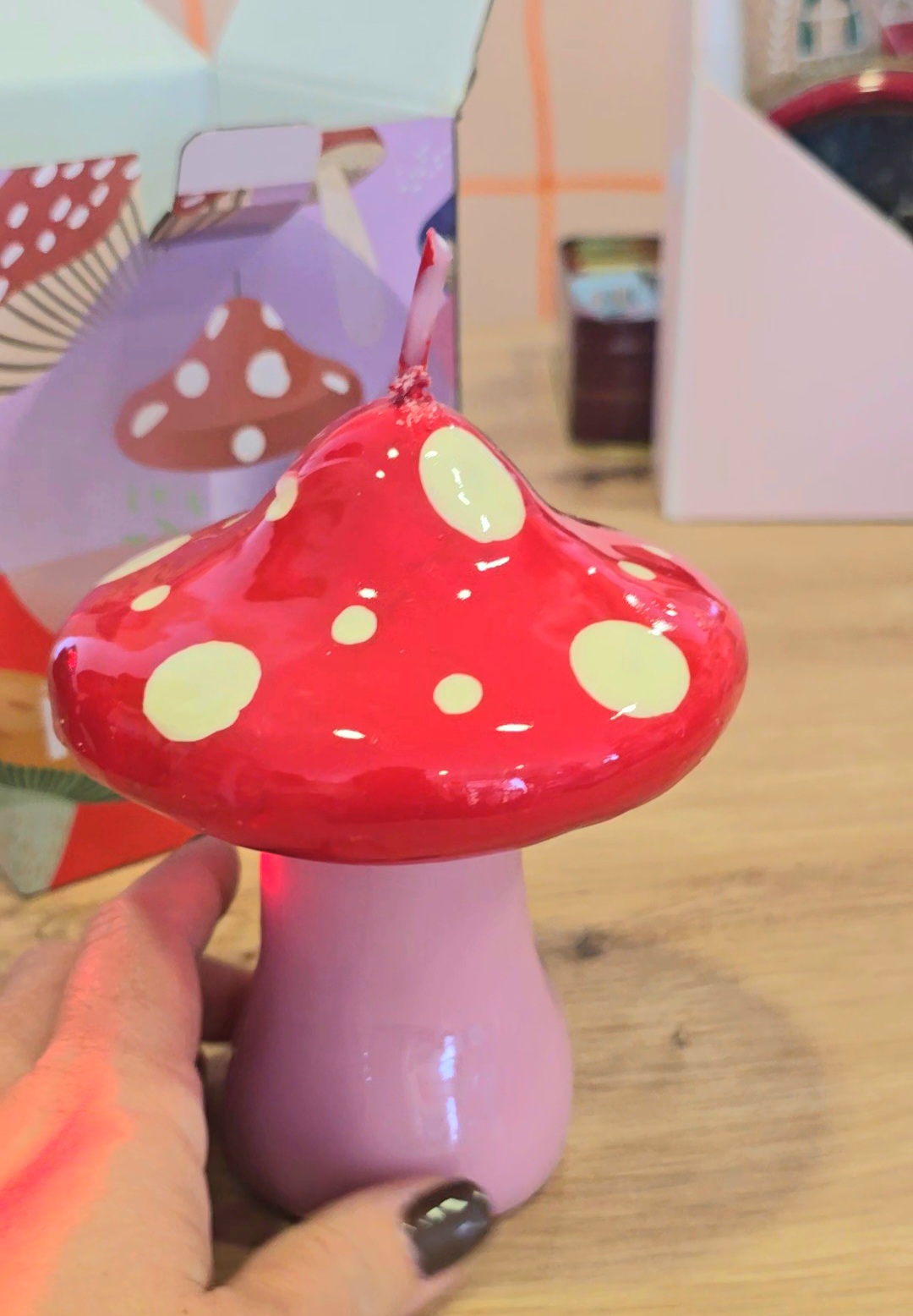 Vela em forma de cogumelo vermelho com manchas brancas e base rosa