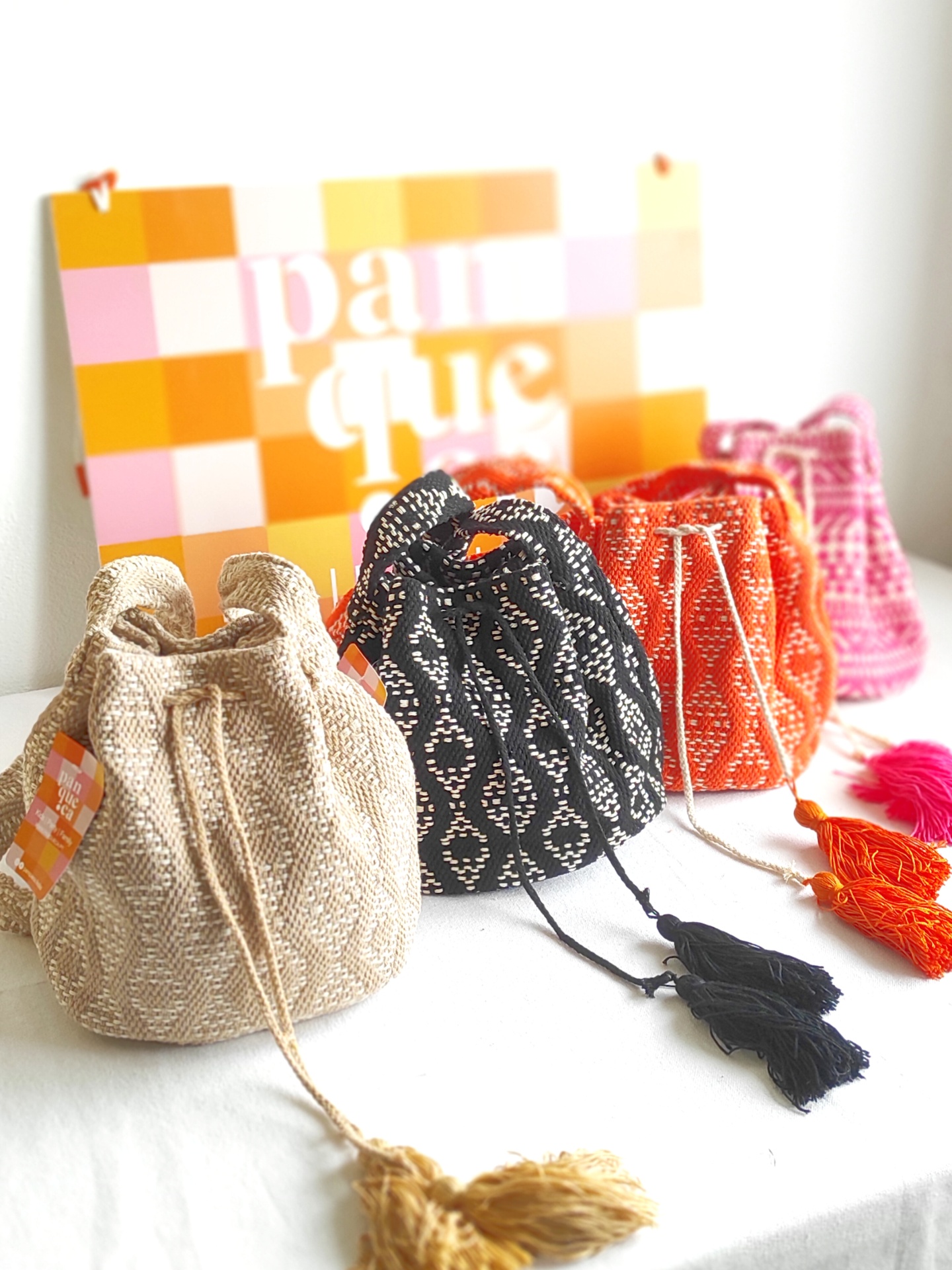 Quatro sacos de tecido com padrões e franjas em várias cores
