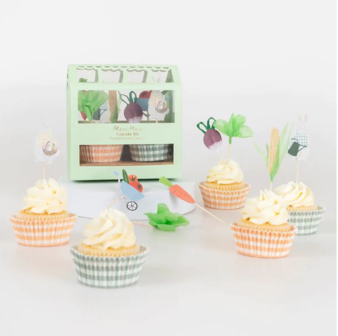 Cupcakes com forminhas às riscas e toppers em papel colorido, caixa verde clara ao fundo.