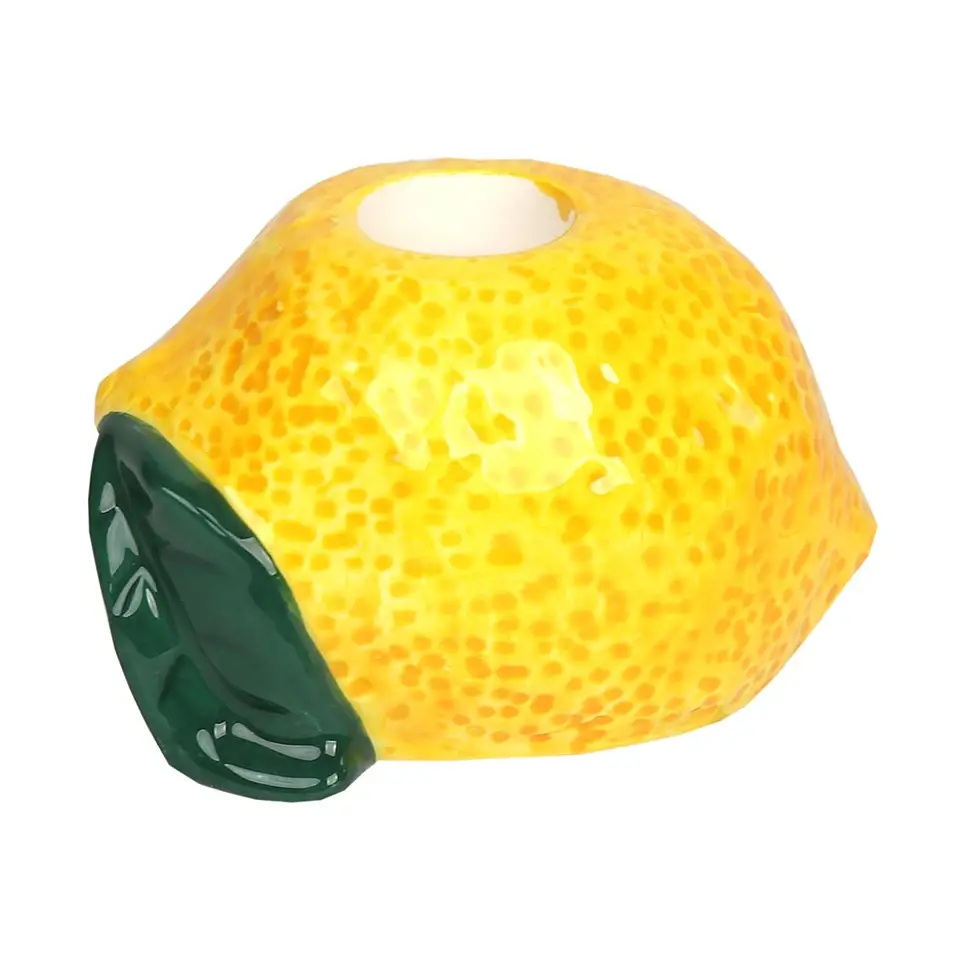 Vela em forma de limão amarelo com folha verde em fundo branco