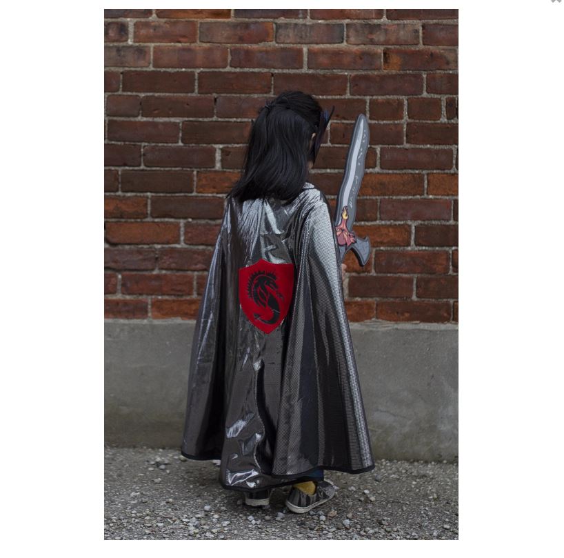 Criança de costas com capa preta e escudo vermelho segurando espada de brinquedo