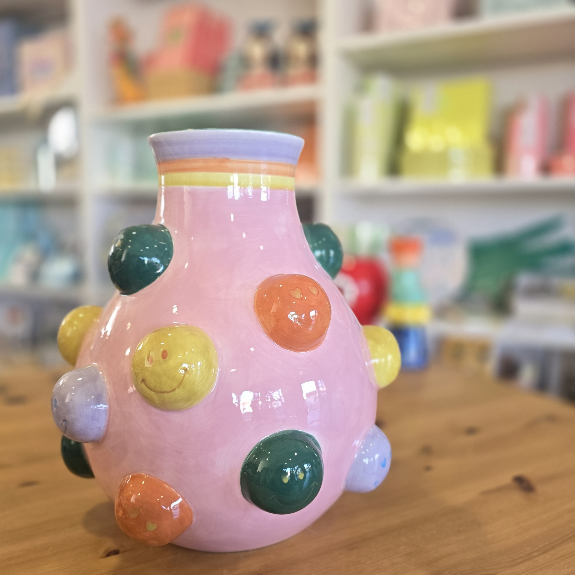 Jarra de cerâmica rosa com bolbos coloridos e carinhas sorridentes
