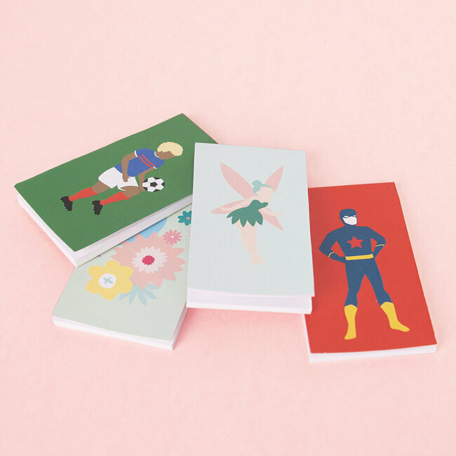 Quatro cadernos pequenos coloridos com ilustrações de jogador de futebol, fada, flores e super-herói