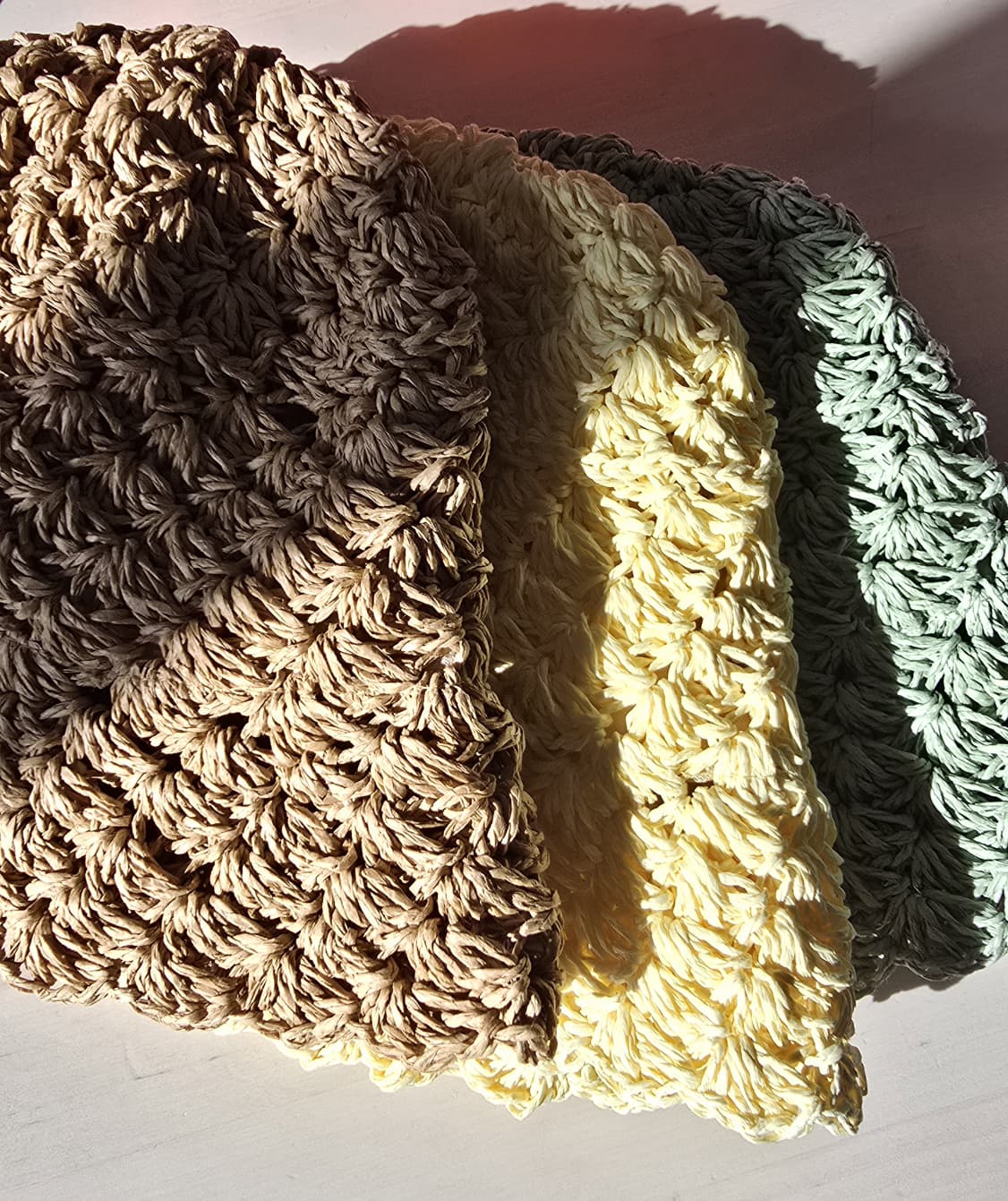 Gorros de malha grossa nas cores castanho, amarelo claro e verde com padrão texturizado