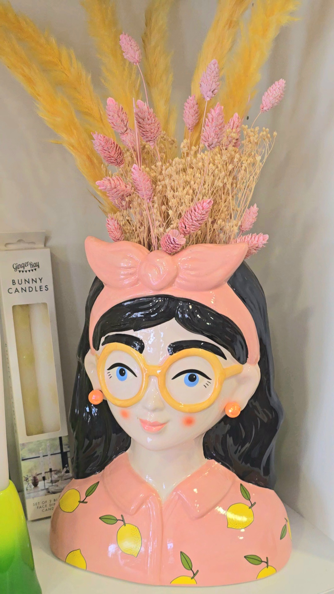 Vaso decorativo de cerâmica com rosto de mulher e flores secas